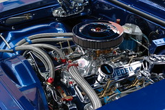 A shiny, obviously well-kept engine under the open hood of a car.
