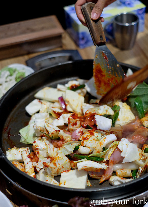 Adding gochujang hot pepper paste to the dakgalbi spicy chicken bbq at PR Korean Restaurant, Lidcombe