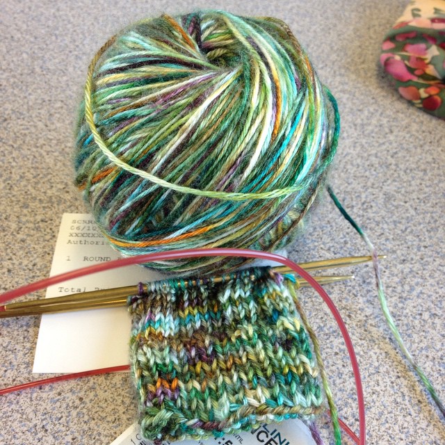 Knitting baby socks on the train. Yarn is Merino-tussah silk by Shaggy Bear Farms.