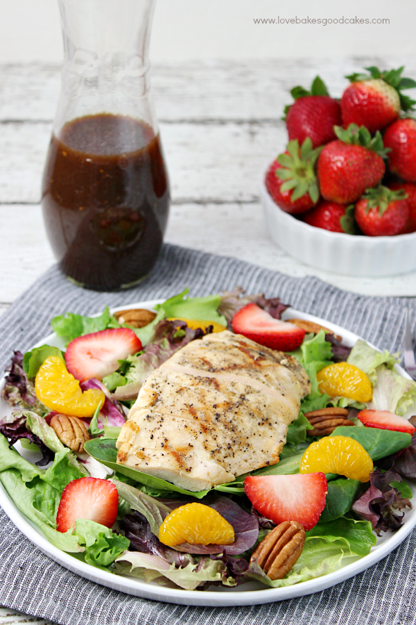 California Chicken Salad on a plate with fresh strawberries in a bowl.