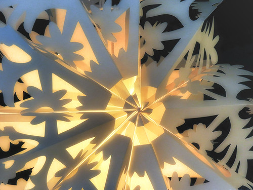 Christmas decoration of a snowflake made of folded paper with cut-outs