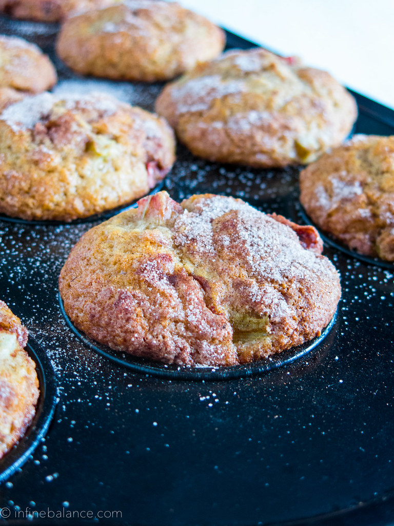 a tray of rhubarb muffins with icing sugar