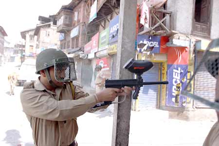 Policeman firing a pellet gun