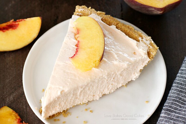 No-Bake Peach Cheesecake on a white plate with fresh peaches close up.