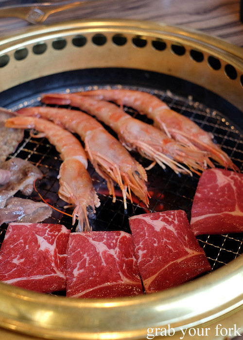 Cooking beef loin and prawns over charcoal at Gyakaku Yakiniku in Osaka, Japan
