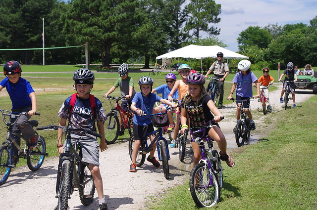 Jr. Rangers biking and learning about making and extinguishing camp fires at York River State Park, Virginia