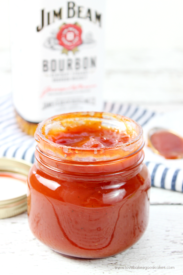 Bourbon Whiskey BBQ Sauce in a glass jar with a bottle of Jim Beam.
