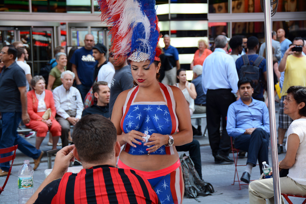 A woman wearing body paint walks through Times Square in 