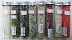 保麗龍回收後製成的聚苯乙烯(PS)粒子(左邊三瓶)，依顏色區分等級。