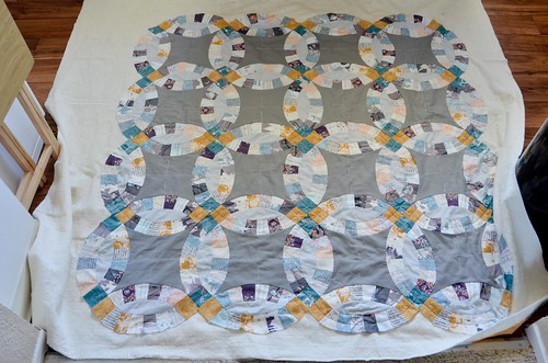 Front of quilt with completed machine quilting, basting still in