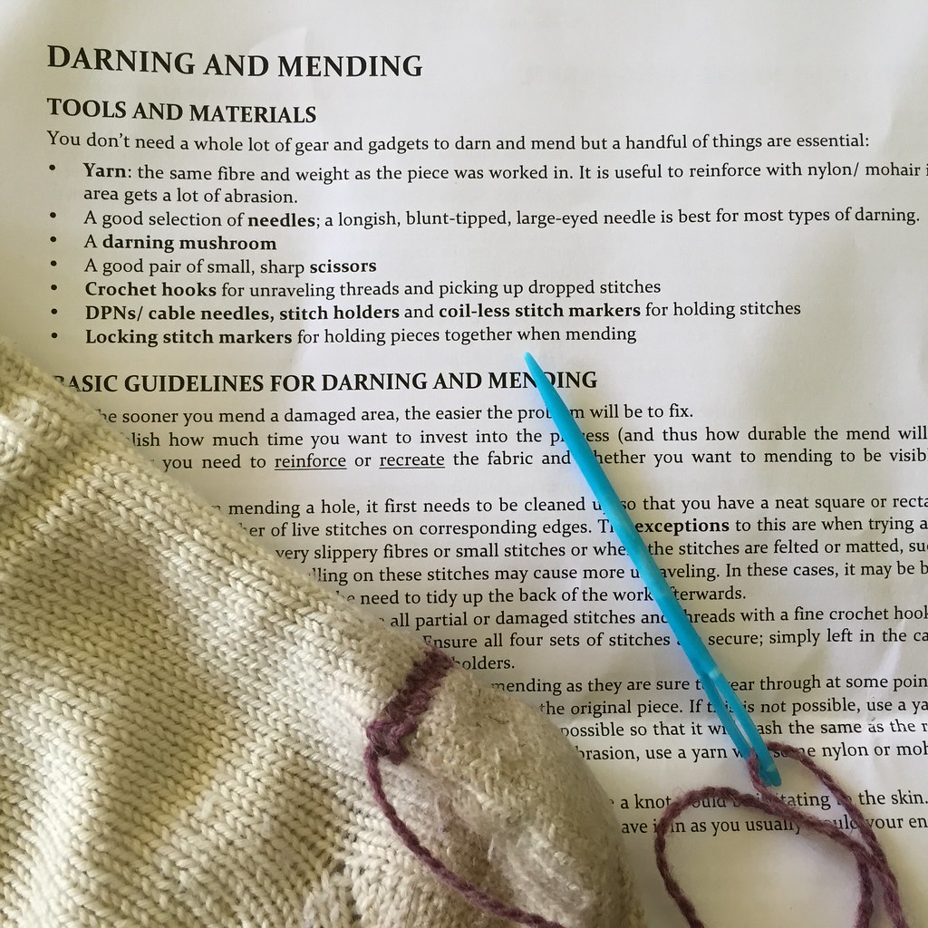 startint to reinforce the heel of a hand knitted sock, with the darning class notes in the background