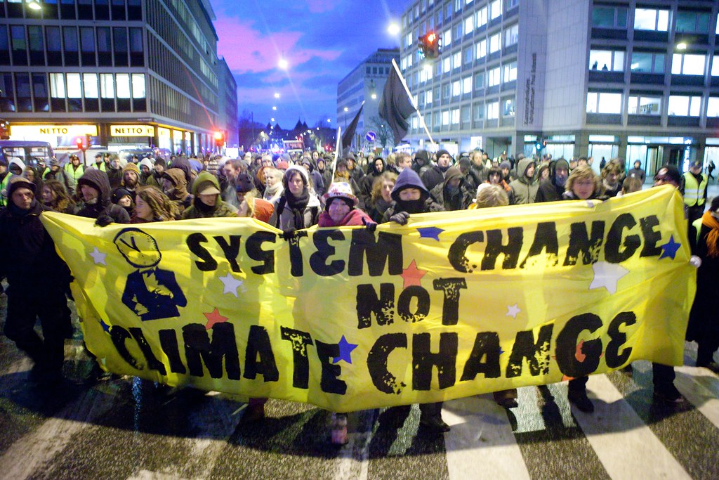 「要體系變遷，不要氣候變遷」（System change not climate change）是每一屆COP會議場外群眾訴求最具代表性的口號。（圖片來源：Kris Krüg/Flickr/CC）