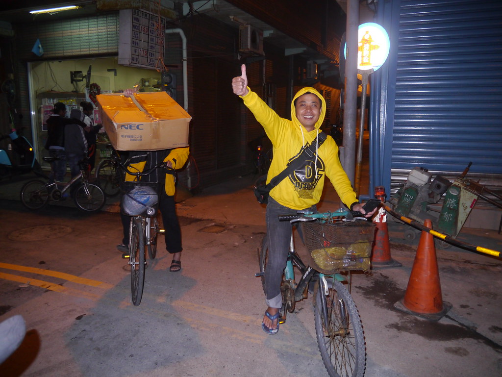 印尼漁工領走冬衣後，開心的用腳踏車運送回自己居住的漁船。（攝影：Asuka Lee）