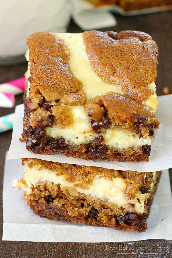 Chocolate Chip Cheesecake Bars stacked on parchment paper close up.