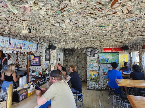 Captain Lou's bar with currency on walls and ceiling