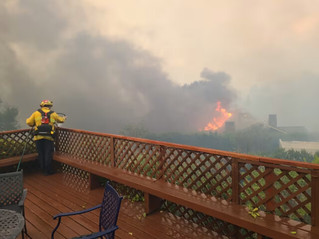 crew member applies fire-retardant to a home