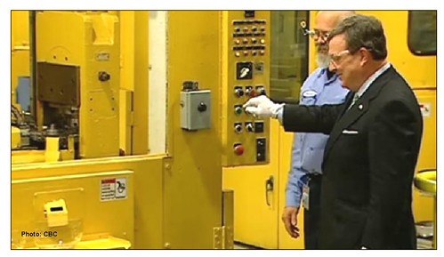 Pressing button on minting press for the last Canadian cent