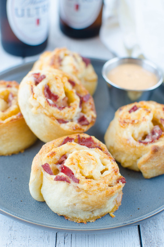 Corned Beef Pizza Rolls - corned beef, swiss cheese, and thousand island dressing rolled up in pizza dough and baked until golden and delicious! Only 4 ingredients and totally addictive!