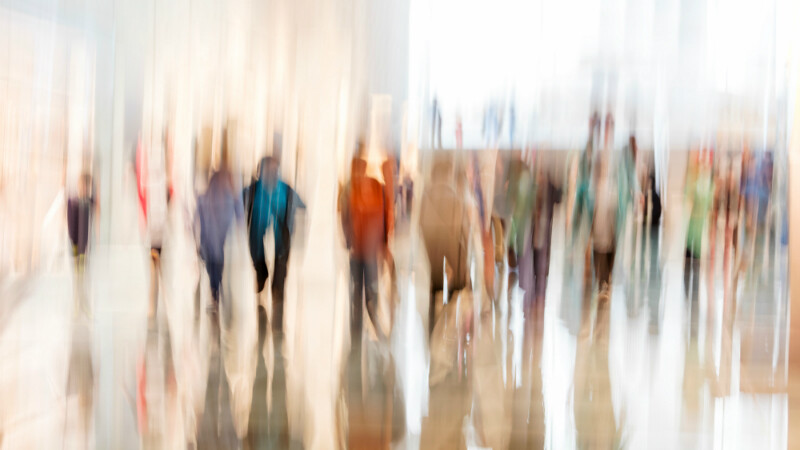 Blurred out image of individuals exploring a museum space.