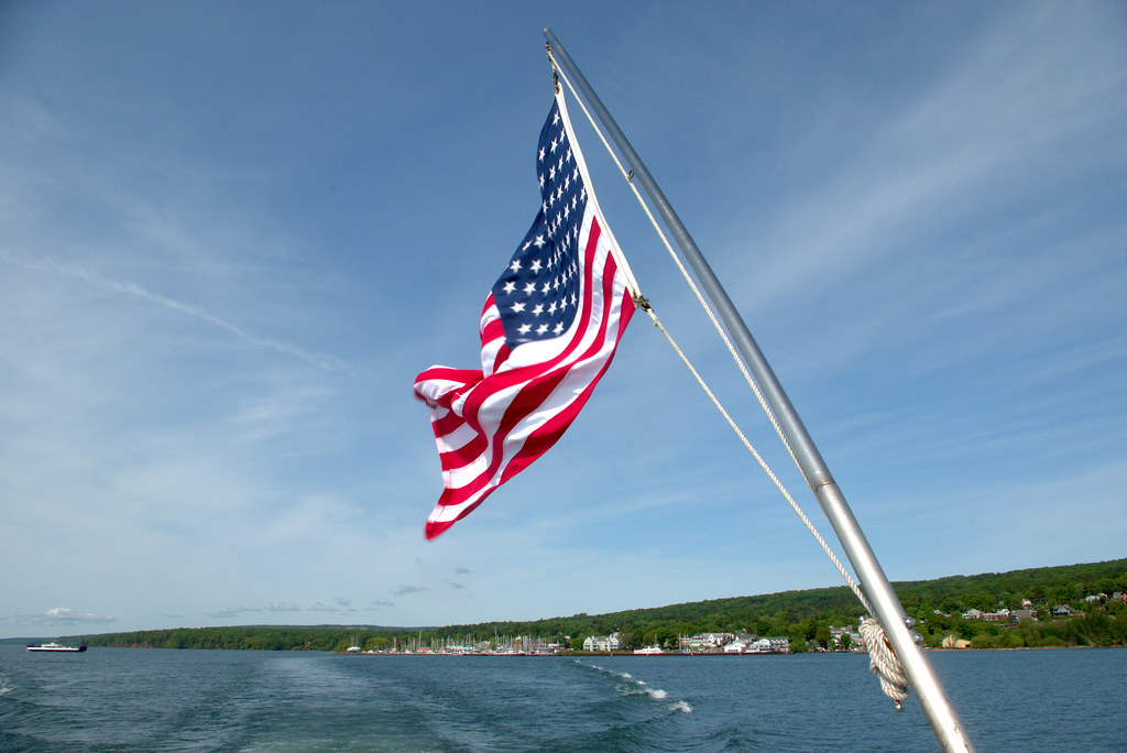 US Flag on Apostle Island Cruises tour boat, near Bayfield, Wisconsin, June 7, 2018. Photo shared as public domain on Pixabay as “Tour Boat US Flag.”