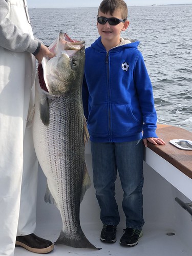 Photo of boy with a huge striped bass he caught