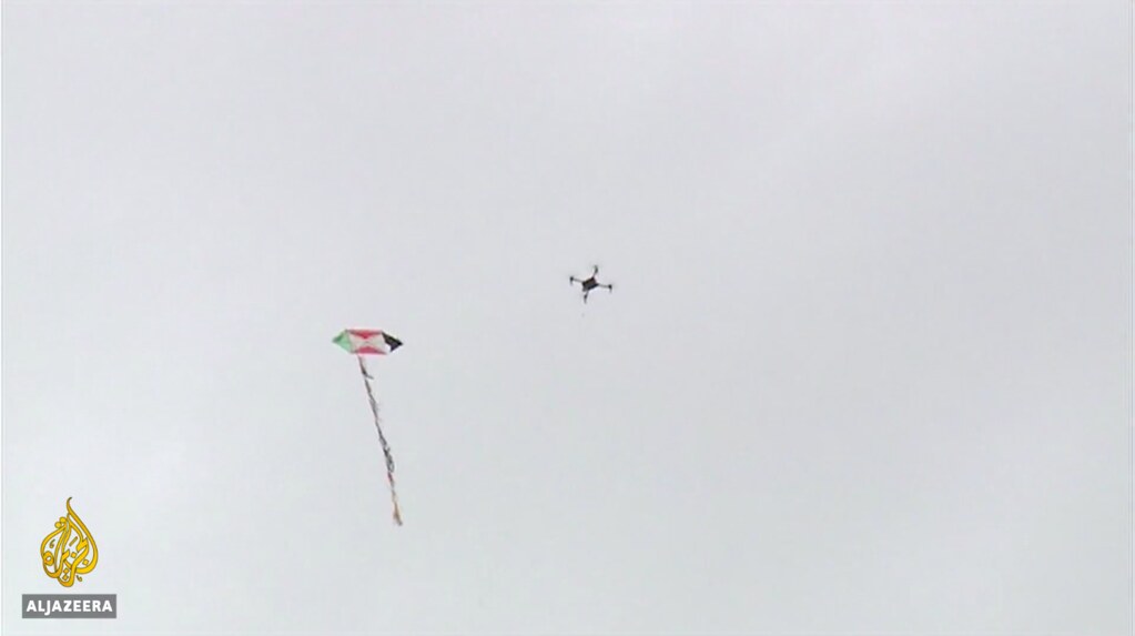 巴勒斯坦人施放風箏突破加薩邊境，右為以色列無人機。（圖片擷取自半島電視台）