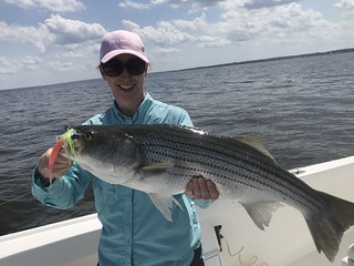 Woman holding a nice striped bass.