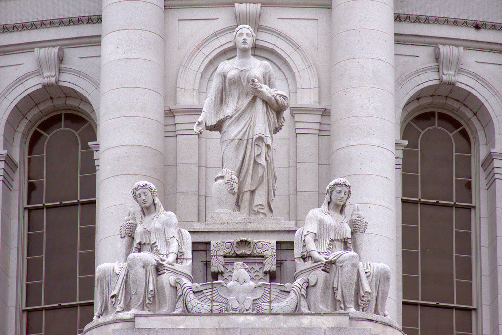 Prosperity and Abundance statuary group on the Wisconsin State Capitol Building, photographed during the weekly Dane County Farmers Market Saturday on the Square, Madison, Wisconsin, June 2, 2018. Photo shared as public domain on Pixabay and Flickr