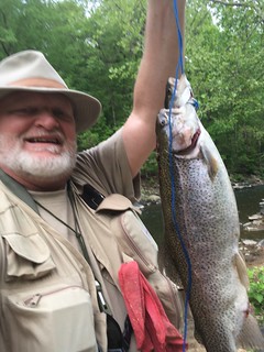 Photo of man holding up his rainbow trout