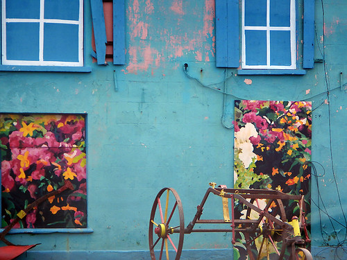 A boarded-up building in Port Magee, Ireland is made vibrant with painted flowers and false windows