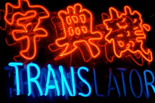 A neon sign announcing a translator. Also written in Chinese.
