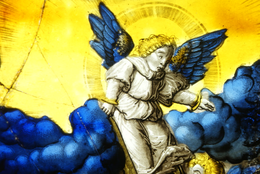 Vitrage représentant un ange monstrueux sur un nuage d'un bleu éclatant.