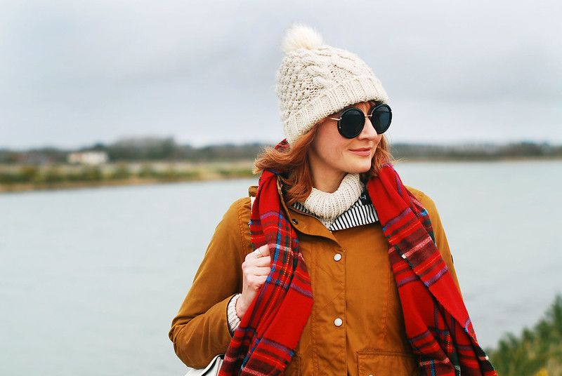 Cold weather preppy outfit for the coast: Brown Barbour jacket cream bobble hat and roll neck red tartan scarf black skinnies and riding boots | Not Dressed As Lamb, over 40 style blog