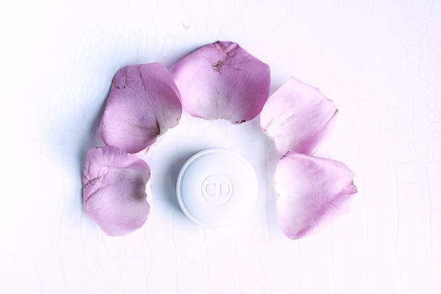 Dior Crème de Rose Smoothing Plumping Lip Balm surrounded by rose petals