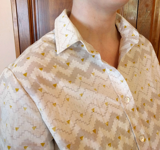 Close up of the collar and buttonband of a shirt worn by a woman.