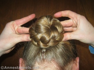 Finishing pushing in the bobby pins around the braided bun - 12 Pretty & Practical Hiking Hairstyles