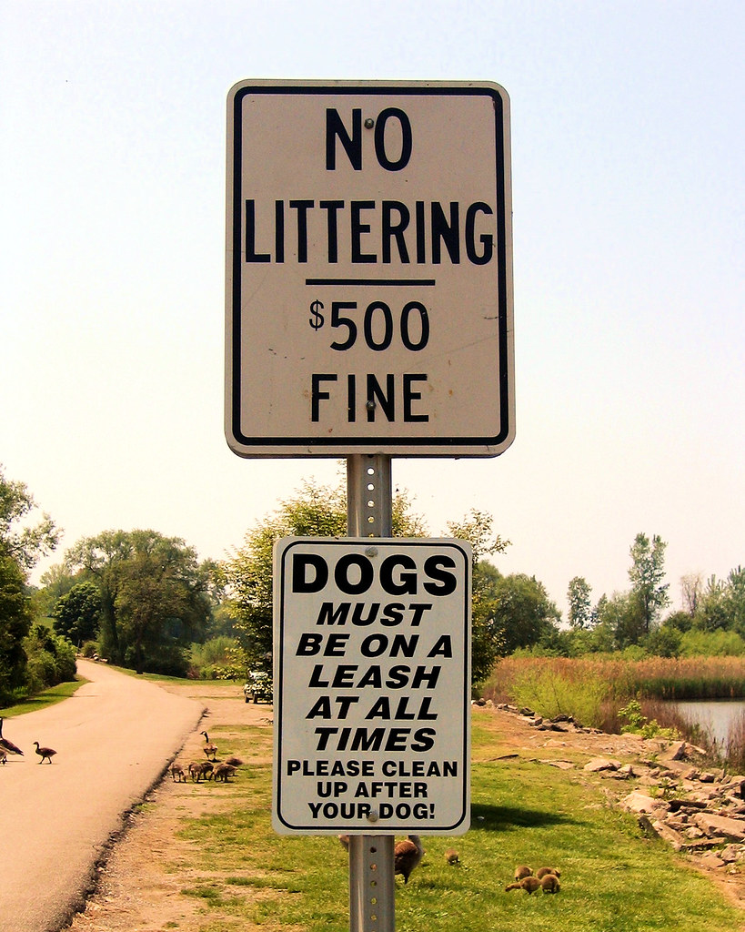 Sign (“No littering - $500 fine”, “Dogs must be on a leash at all times. Please clean-up after your dog!”) near Conneaut Harbor in Conneaut, Ohio