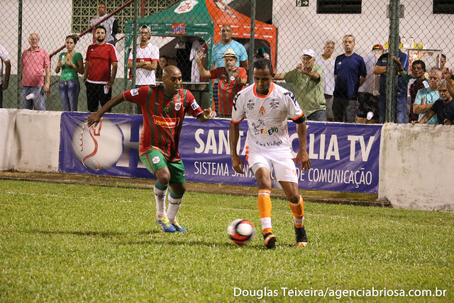 Adiel, meia da Portuguesa Santista, disputa bola com jogador o Atibaia