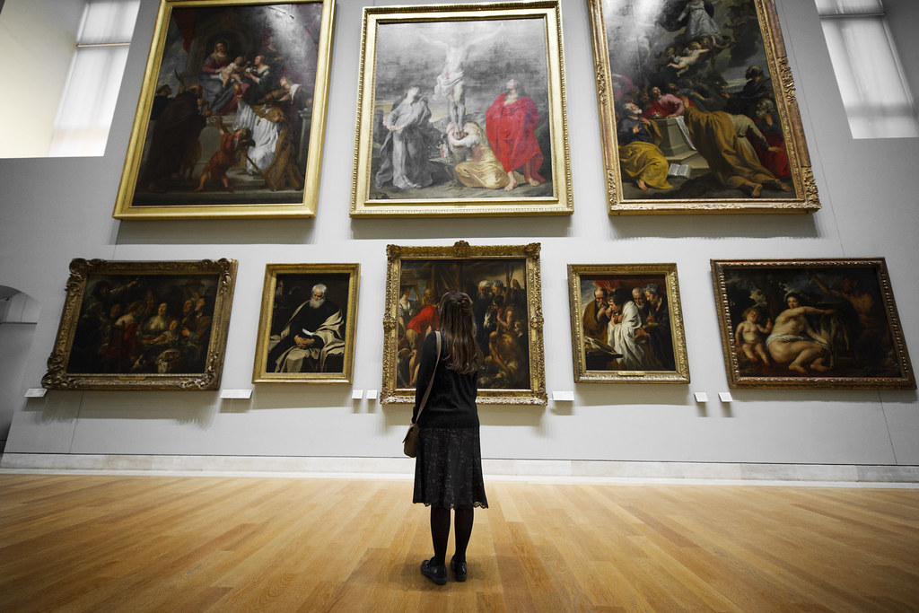 An image of a woman observing art pieces in a museum