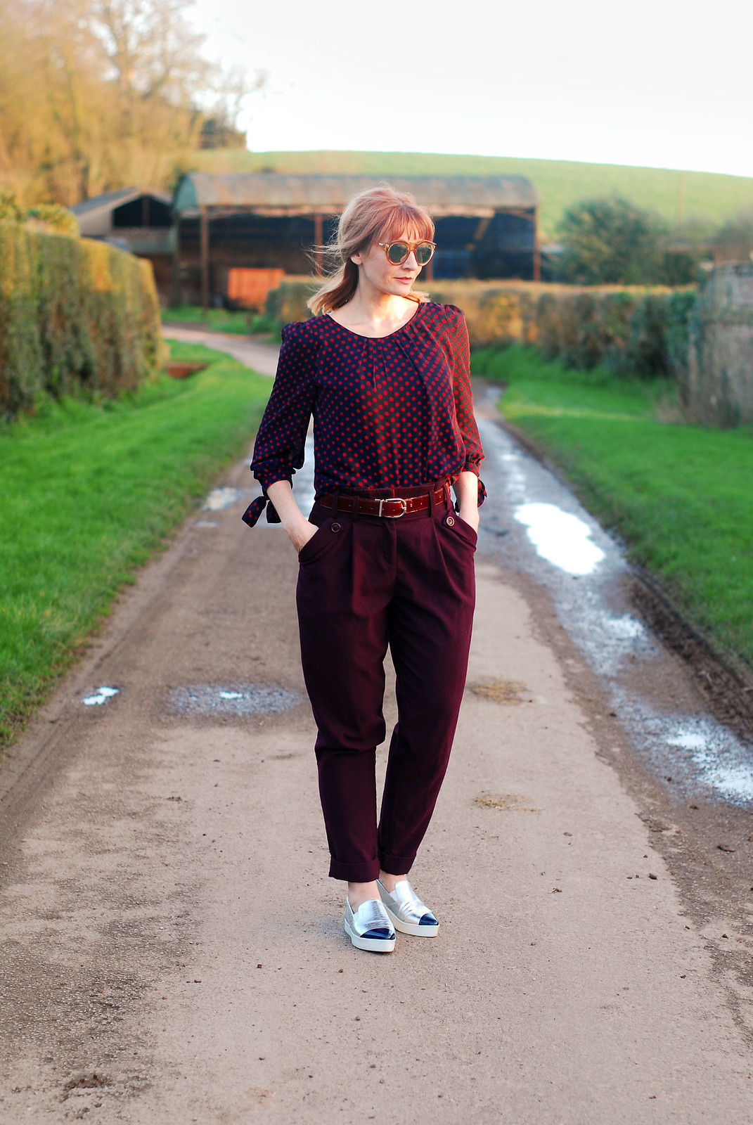 Easy-to-wear colours of plum and navy blue: Red and blue polka dot blouse plum peg leg trousers silver pointed toe slip trainers | Not Dressed As Lamb, over 40 style