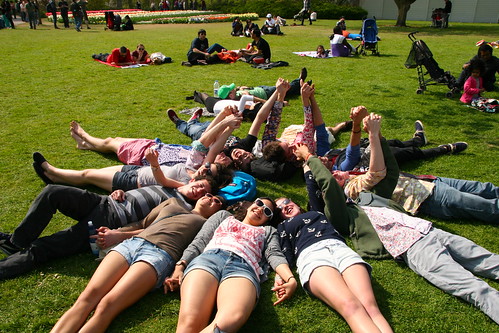 Friends around the world: Students lounge on the grass in a circle in a park in Keukenhof, Netherlands.