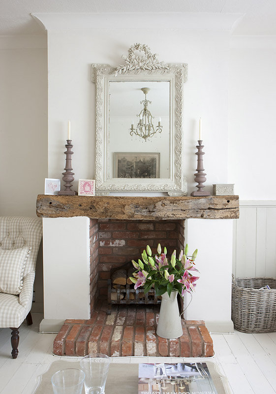 Farmhouse shabby chic living room with distressed brick, distressed wood mantle, antique white ornate mirror