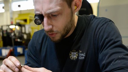 Royal Mint employee examines new pound coin