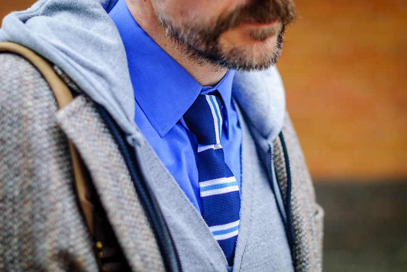 A layered smart casual outfit: Striped tie \ dress shirt \ grey cardigan \ grey hoodie \ Harris tweed jacket \ jeans \ grey brogues | Silver Londoner, over 40 menswear