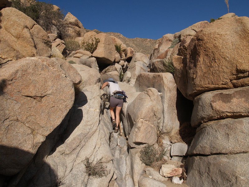The going gets steep as we head up-canyon. This is Vicki scrambling up the granite rock of a dry waterfall