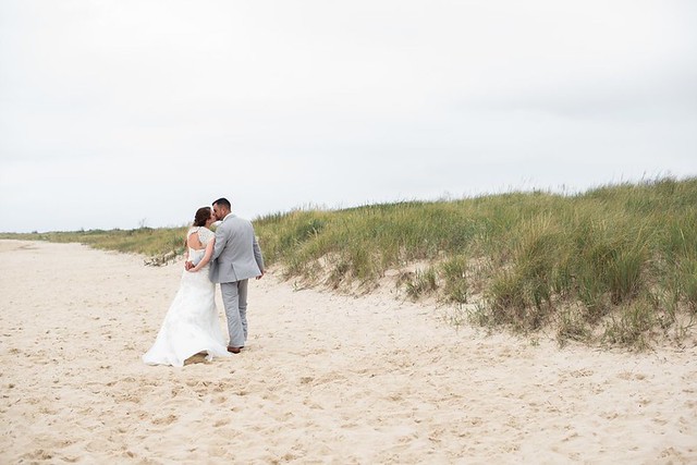 The simplicity of walking hand in hand along the beach is very romantic. First Landing State Park Wedding photo courtesy of Caitlin Gerres Photography