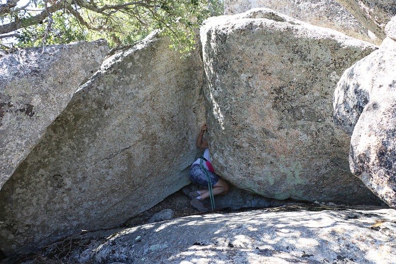 Vicki sneaking under two large granite boulders - the only path we found to the top