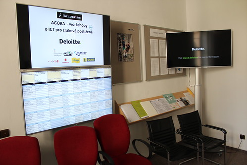 LCD obrazovky s logy partnerů, rozvrhem a prezentačním videem společnosti Deloitte, hlavního partnera Agory pro letošní rok