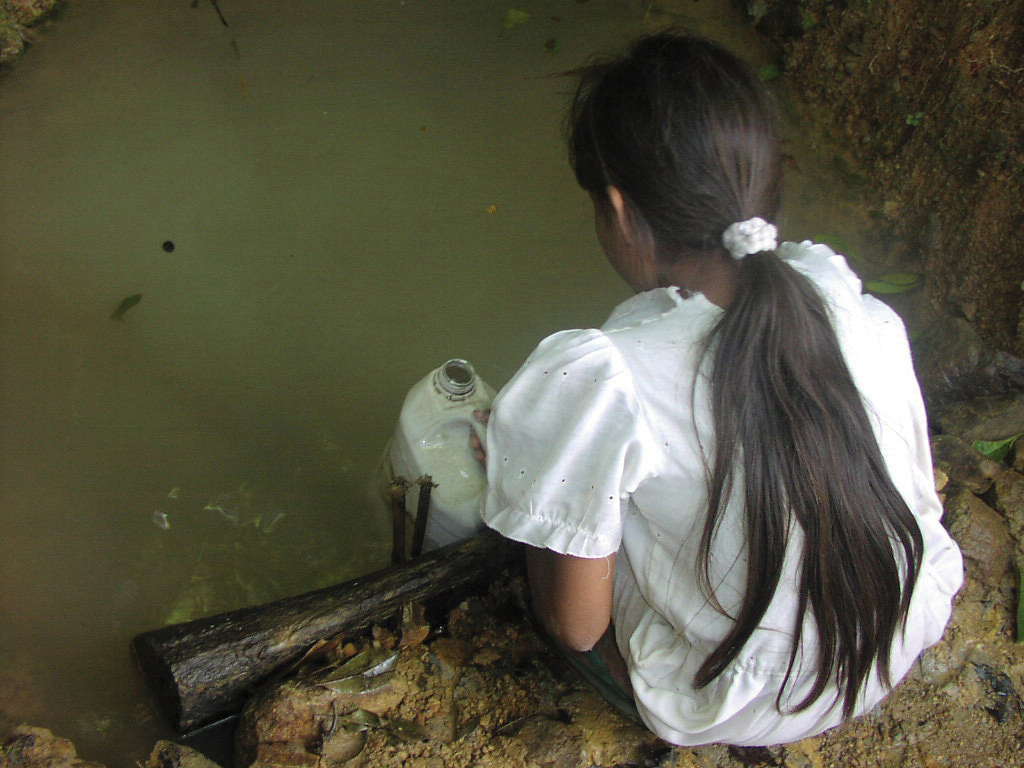 一名宏都拉斯女孩正從遭污染的水源取飲用水。圖片來源：Cecilia Snyder（CC BY-NC-ND 2.0）