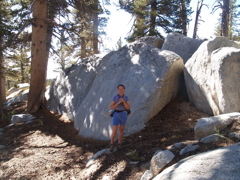 The unmaintained Tamarack Trail enters a forested area with large granite boulders